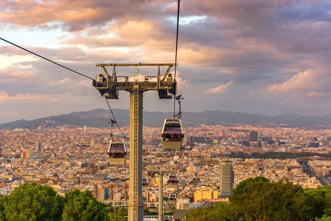 Cable cars above Barcelona during sunset with city view