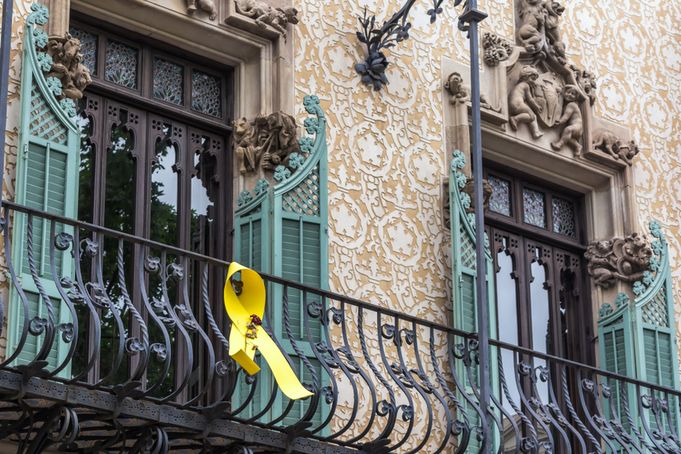 Close-up of Casa Amatller's balcony with green shutters and yellow ribbon