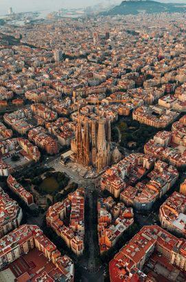 Aerial view of Barcelona featuring the Sagrada Família and city streets.