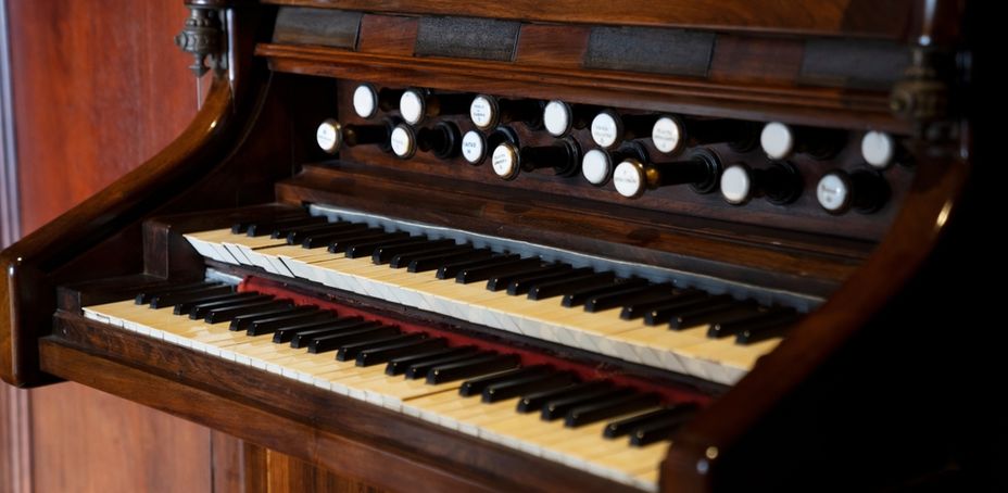 Image of an antique organ with wooden keys and control panel, part of the Palau Güell collection.