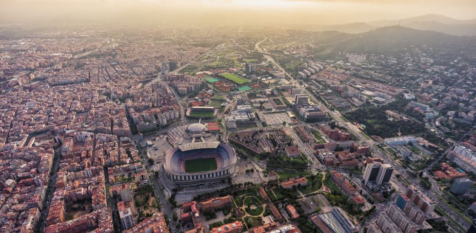 Aerial perspective of the iconic Camp Nou stadium amidst a bustling urban landscape.