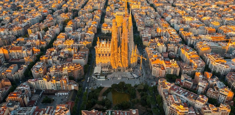 Aerial view of Barcelona Eixample residential district and Sagrada Familia Basilica at sunrise.