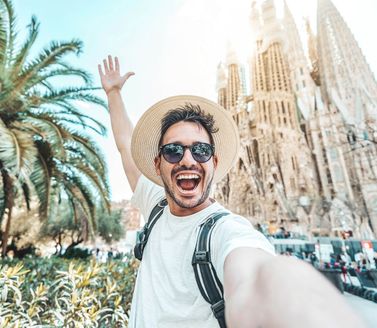 Smiling tourist taking a selfie near Sagrada Familia in Barcelona