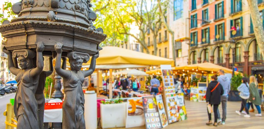 La Rambla sunny street with many walking people. La Rambla - most popular pedestrian street in Barcelona.