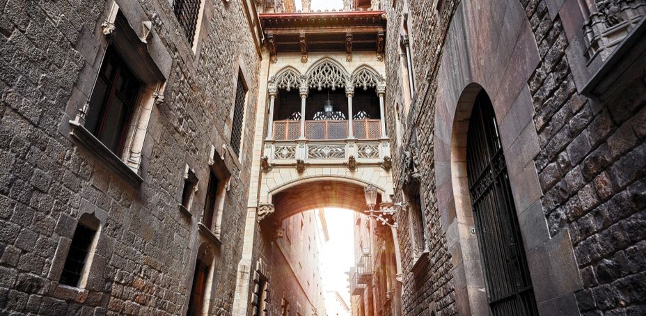 Gothic Quarter in Barcelona, Spain. Antique Bridge between stone walls of medieval buildings in in old town.